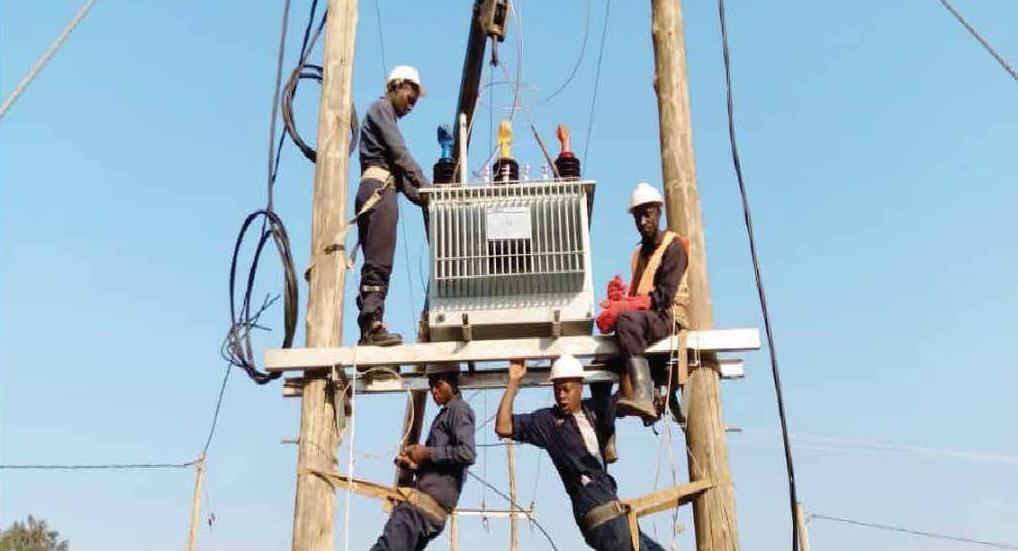 KASI team installing a transformer during a rural electrification project
